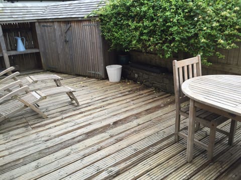 Rear garden decked area with table and steam lounger chairs