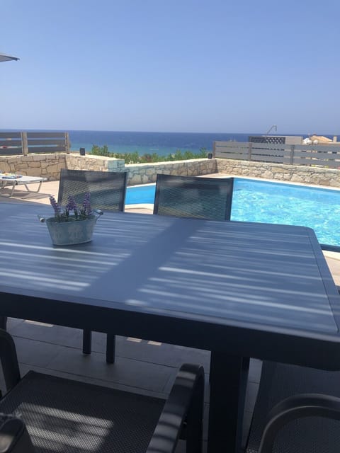 Dining on the terrace by the pool with sea views