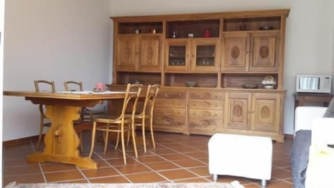 The dining room with the large table and the handcrafted walnut-wood cupboard