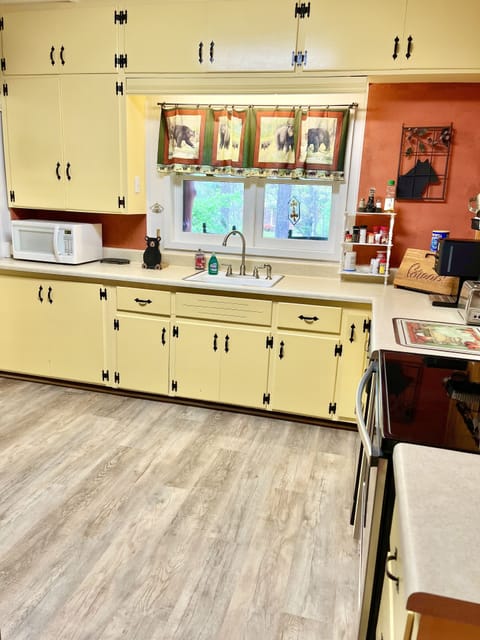 Kitchen with plenty of cookware, microwave, cooking utensils