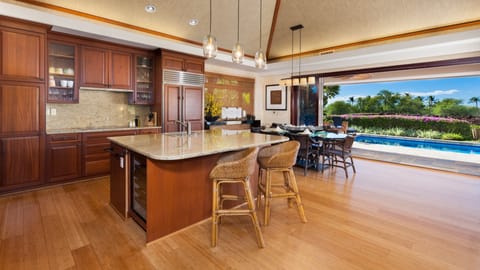 Gourmet kitchen equipped with wine fridge, spices and oils.