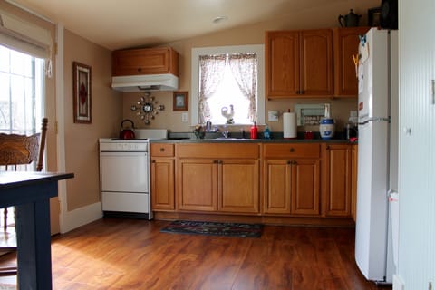 Full kitchen with stove and refrigerator.