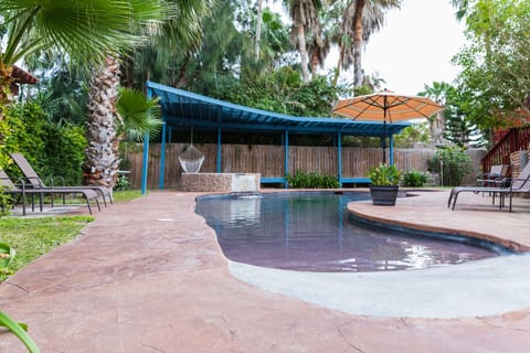 Beach entry pool with hot tub, plenty of seating with shade.