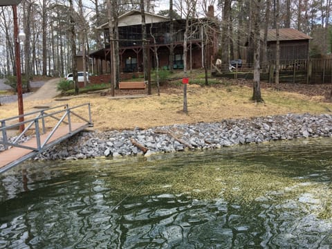 Gentle slope to water. View of home from boat dock with swim pier attached. 