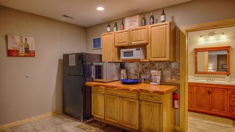 Lower level wet bar has sink, microwave, coffeepot, wine cooler, fridge.