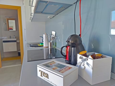 Dolce gusto coffee machine with capsules, kettle with tea box.