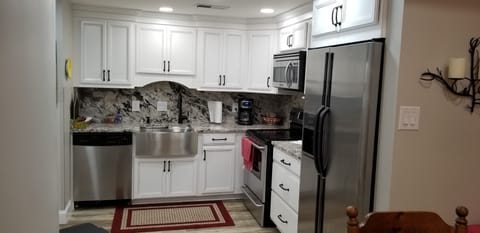 granite countertops, stainless steel appliances and farmhouse sink