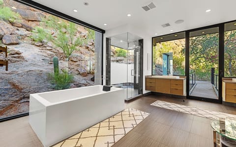 Modern bath with natural light, sleek finishes & seamless indoor-outdoor flow.