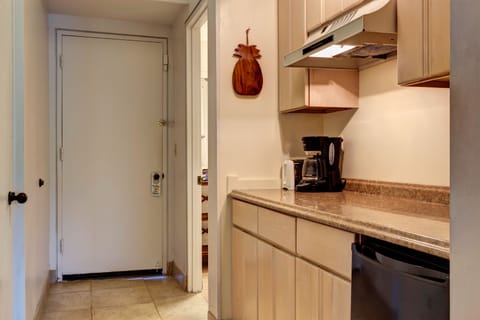 Cabinets with utensils, glassware, spices, bowls, and undercounter refrigerator.
