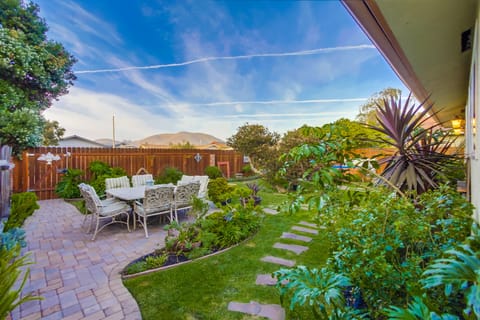 Stone patio table surrounded by lush garden and our signature Melaleuca tree.