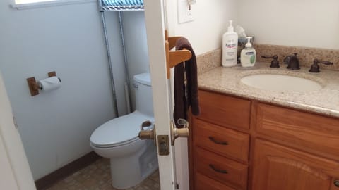 ONE Bathroom.  Door between the room with two sinks & the shower/commode area. 