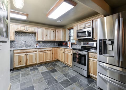 Another view of the kitchen with granite counter tops and slate floors.