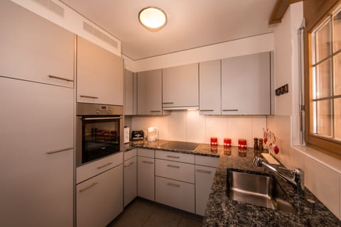 Modern kitchen with granite surfaces, ceramic hob, dishwasher and microwave oven