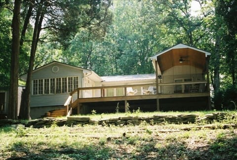 Lakehouse from Back; Sunroom, Deck, and Covered Porch with swing and fan.