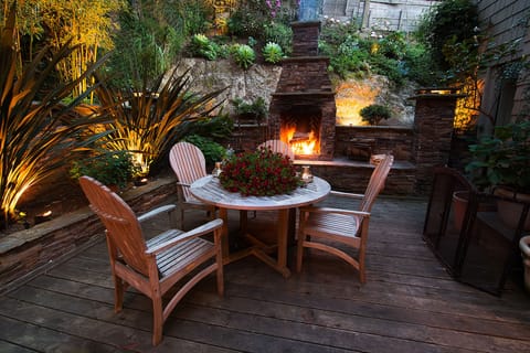 Back deck in early evening with huge outdoor stone fireplace