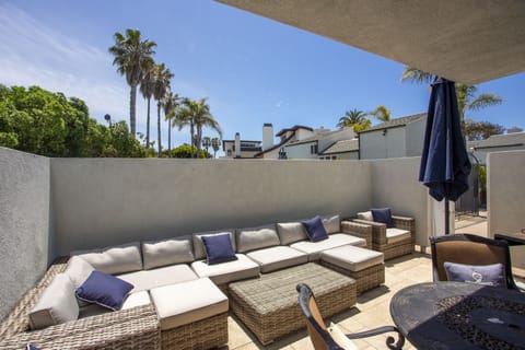 Large private outdoor patio area features a bbq, sofa, dining table.  