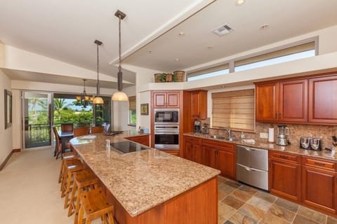 Full kitchen with breakfast bar, granite counters, and stainless steel appliances