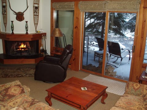 Cozy sunken den with wood-burning fireplace after an early winter snow.