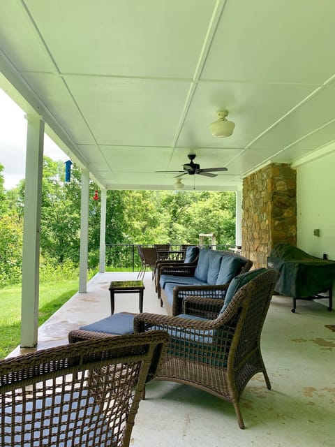 The side porch has relaxing views, comfortable seating, and dining area for 6+