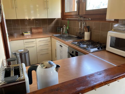 Kitchen with hob, oven, microwave, dishwasher, kettle, toaster, fridge.