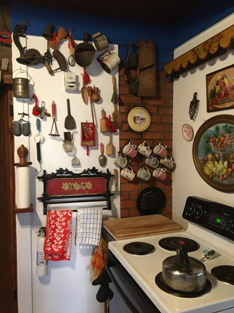 Antique accessories line the walls near the stove.