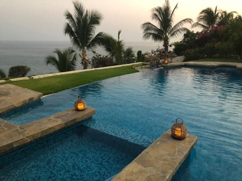 Infinity pool and view of ocean at dusk.