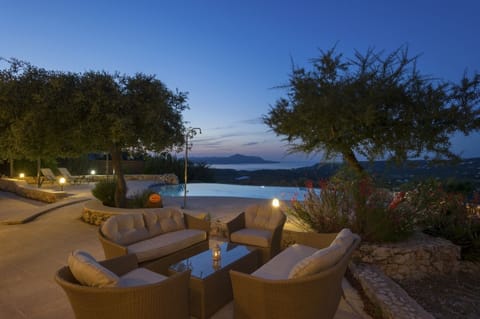 Villa Prinolithos poolside lounge area at sundown.