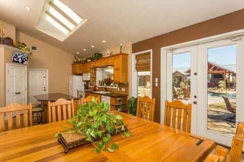 Main house Kitchen.  French doors lead out to patio.  Large table seats 8