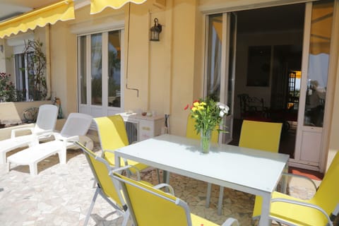 Terrace with sun loungers, table & chairs