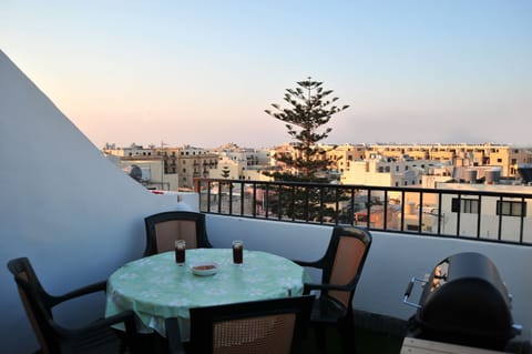 Roof level terrace with chairs, table and gas barbecue