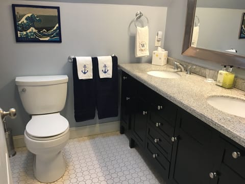 European-style vanity with twin sinks and tub/shower combined.