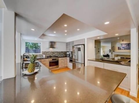 Large gourmet kitchen open on 3 sides with counter stools for 7