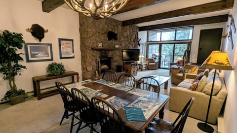 Living room with wood fireplace, sofa bed, and balcony w/ propane BBQ grill