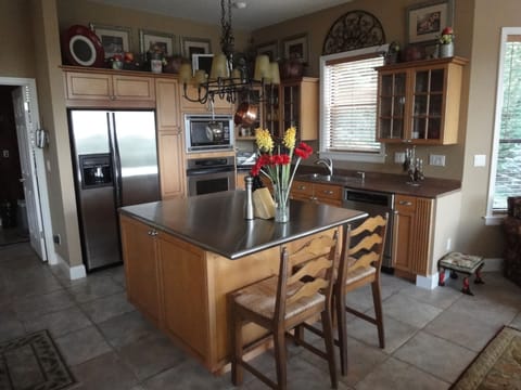 Gourmet kitchen with maple cabinets, stainless steel island & GE appliances.