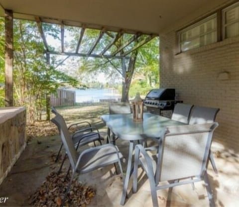 Side porch with covered dining with gas grill.