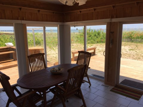 Sunroom with teak table and chairs for dining, entertaining, or game playing.