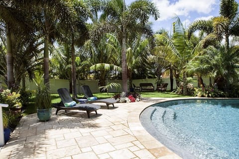 Pool deck area with lawn seating area in grass.  Shallow entry into saline pool.