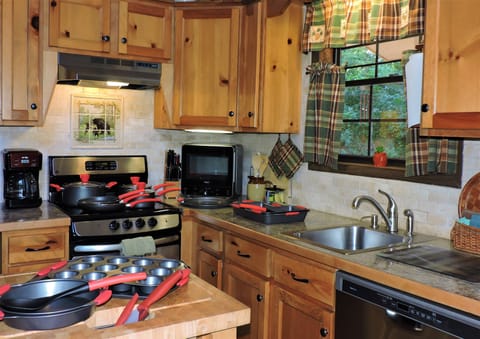 Kitchen with pots and pans, dishwasher and microwave.
