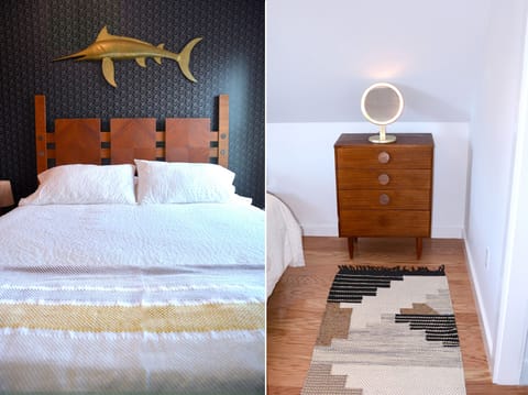 Guest bed with distinctive antiques: headboard, swordfish, and vintage vanity.