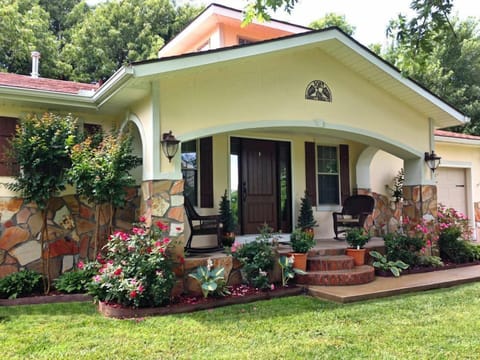 Front of the bungalow in spring. There are roses, hostas, and crape myrtles.