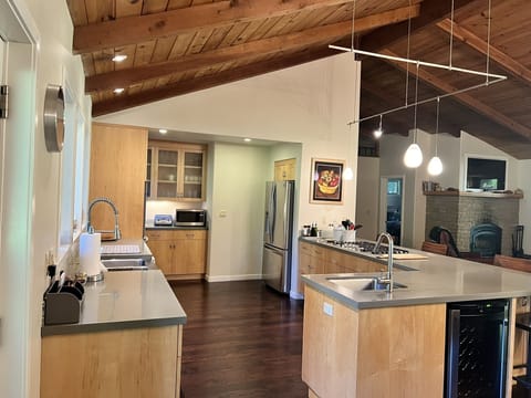 Fully stocked kitchen with a six gas burner cooktop, double oven, & wine cooler