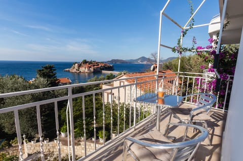 Chairs and table on private balcony with sea view.