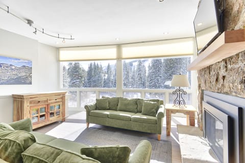 Living Area - Large picture windows, natural lighting, fireplace, and access to the private balcony.