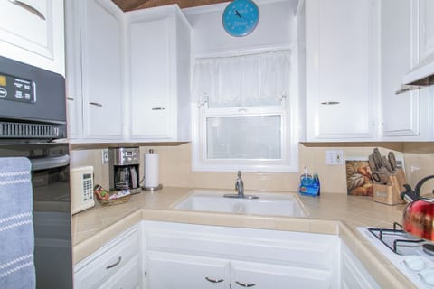 Kitchen with oven, stove, microwave, cookware, and a 12-cup drip coffee maker