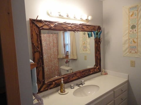 Main Bathroom w/Local Artisan crafted mirror. Shower/ tub combo &Washer/dryer