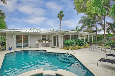 Sparkling lagoon pool with waterfall hot tub and perfect entertaining set up