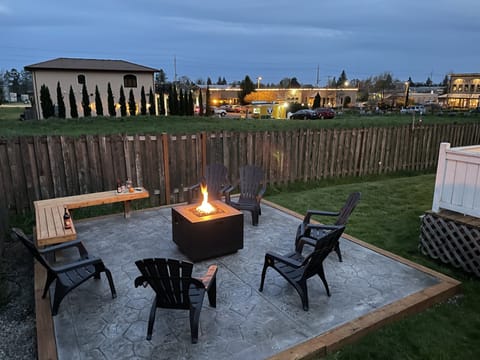 Outdoor fire-pit area with 6 comfortable chairs & bench.