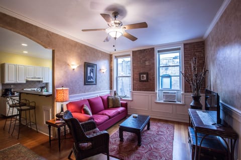 Living room has exposed brick . Television is a smart tv, includes Comcast Cable