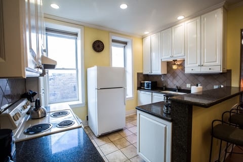 Kitchen has pots, pans, dishes, microwave, oven, dishwasher, coffee pot, etc.