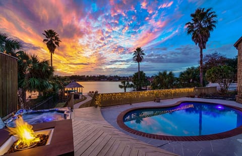 Backyard view with pool, fire pit, hot tub, and palapa